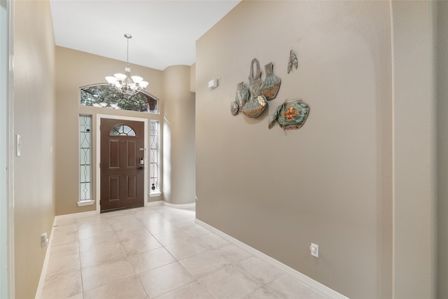 tiled entrance foyer with a notable chandelier