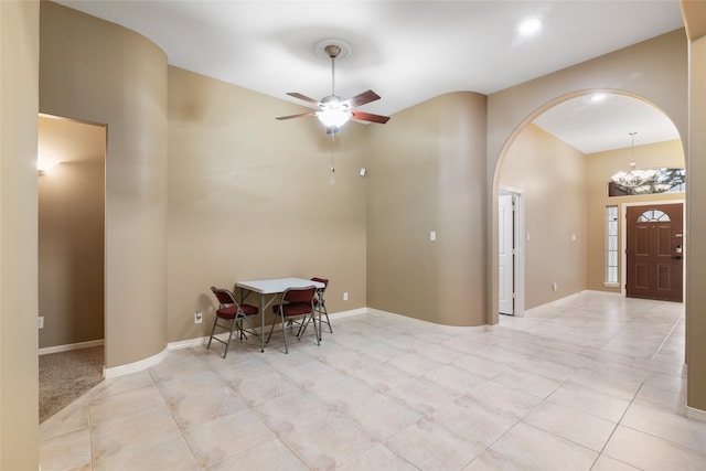 unfurnished dining area featuring ceiling fan with notable chandelier