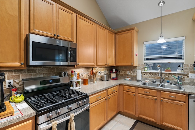 kitchen with sink, vaulted ceiling, stainless steel appliances, backsplash, and light tile patterned floors