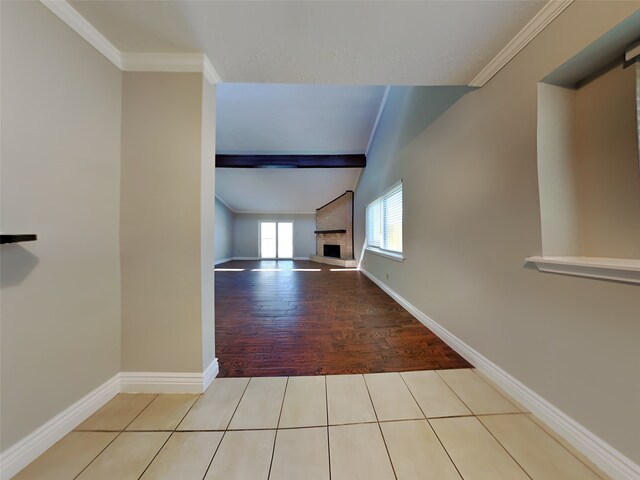 corridor featuring crown molding and light tile patterned floors