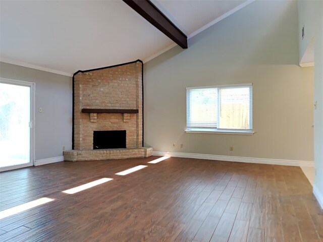 unfurnished living room featuring hardwood / wood-style floors, high vaulted ceiling, a fireplace, beamed ceiling, and ornamental molding