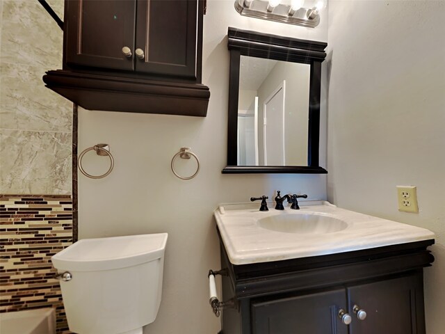 bathroom with vanity, toilet, and a washtub