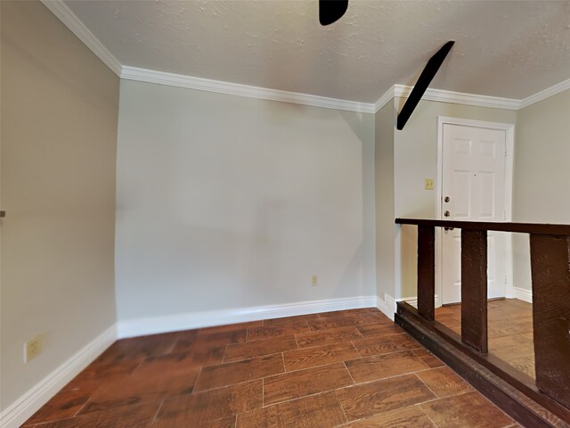 spare room with crown molding and a textured ceiling