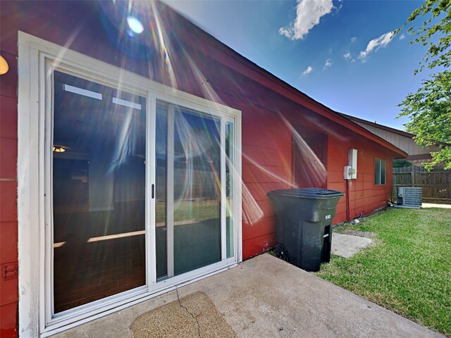 view of side of property featuring a yard, central AC unit, and a patio area