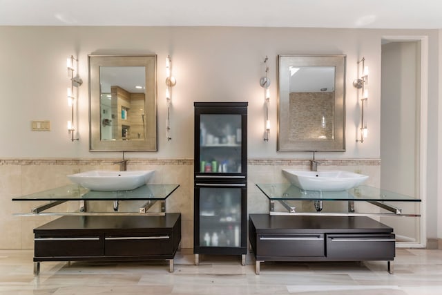 bathroom with tile walls and double sink vanity