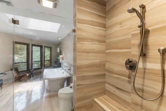 bathroom featuring a skylight, toilet, and shower with separate bathtub