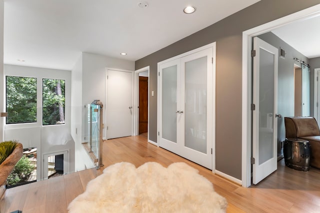 living area with french doors and light hardwood / wood-style flooring