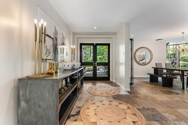 entrance foyer featuring tile patterned flooring, french doors, and an inviting chandelier