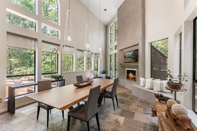 sunroom / solarium featuring plenty of natural light, a large fireplace, and vaulted ceiling