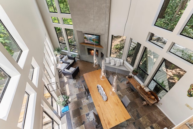 tiled living room with a high ceiling and a wealth of natural light