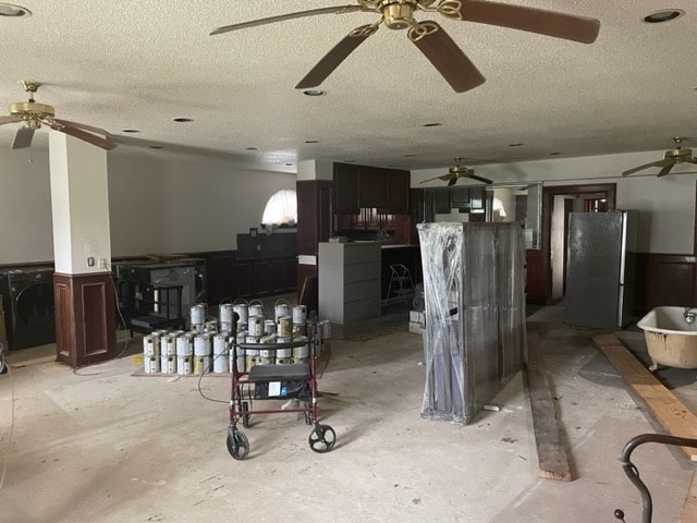 interior space with stainless steel fridge, washer / dryer, and ceiling fan