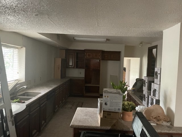 kitchen featuring dark brown cabinetry, sink, a textured ceiling, and dishwasher