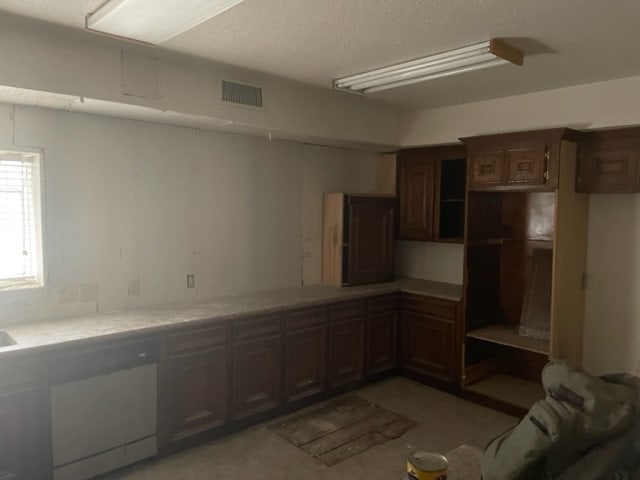 kitchen featuring dishwasher and dark brown cabinets