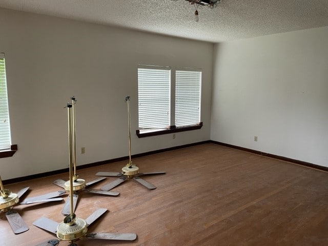 spare room featuring hardwood / wood-style flooring and a textured ceiling