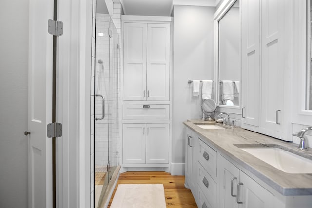 bathroom featuring vanity, hardwood / wood-style flooring, and a shower with door