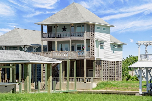 rear view of house with a yard and a balcony