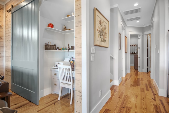 corridor featuring light hardwood / wood-style floors and a barn door