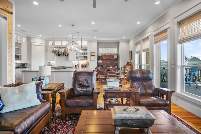 living room featuring a wealth of natural light, ornamental molding, hardwood / wood-style floors, and a barn door