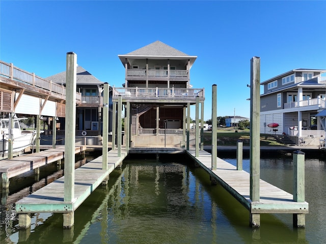 dock area with a balcony and a water view