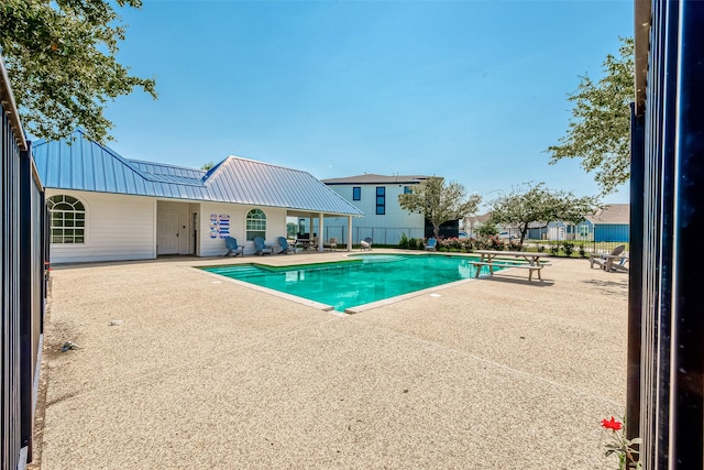 view of swimming pool featuring a patio area and a diving board