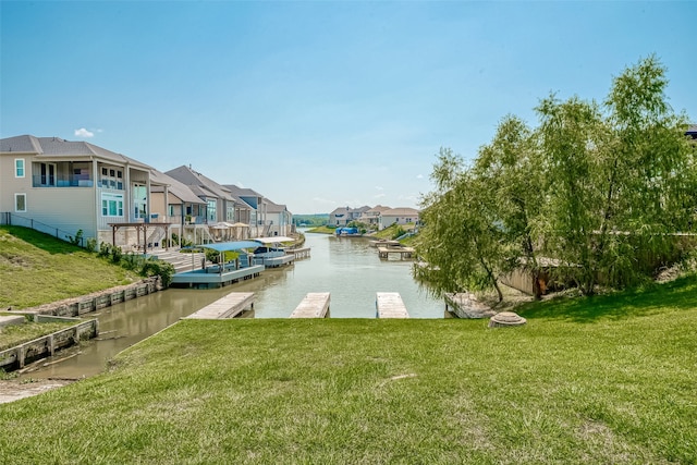 view of dock featuring a lawn and a water view