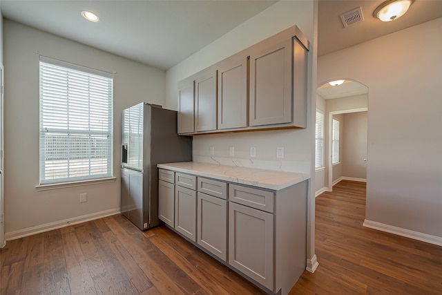 kitchen with gray cabinets, dark wood-type flooring, and a wealth of natural light