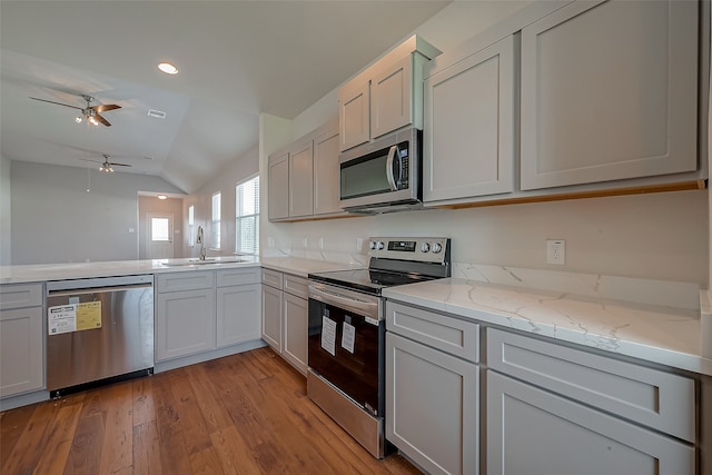 kitchen with light hardwood / wood-style flooring, stainless steel appliances, sink, ceiling fan, and vaulted ceiling