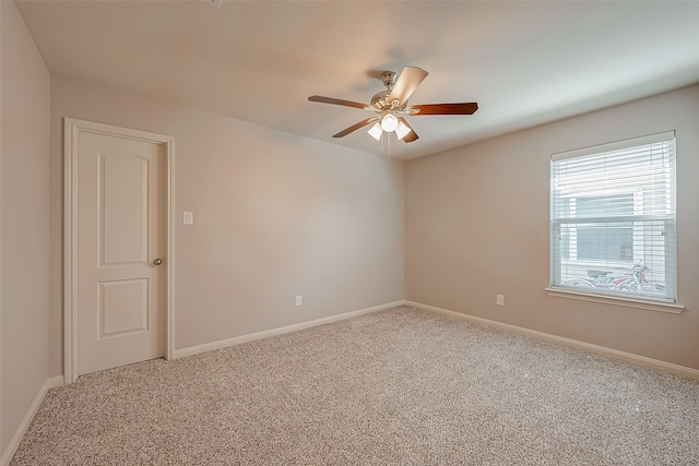 carpeted spare room featuring ceiling fan