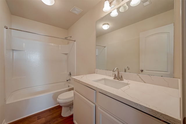 full bathroom with hardwood / wood-style flooring, washtub / shower combination, vanity, and toilet