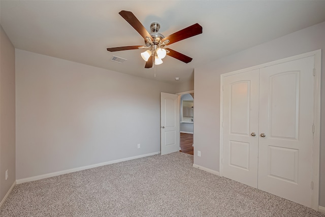 unfurnished bedroom featuring ceiling fan, carpet flooring, and a closet