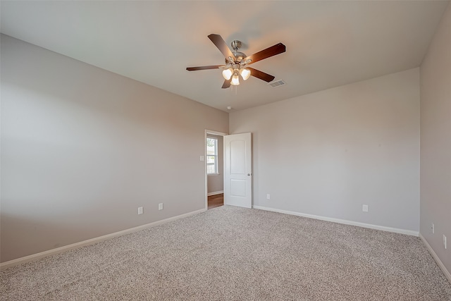 unfurnished room with ceiling fan and carpet