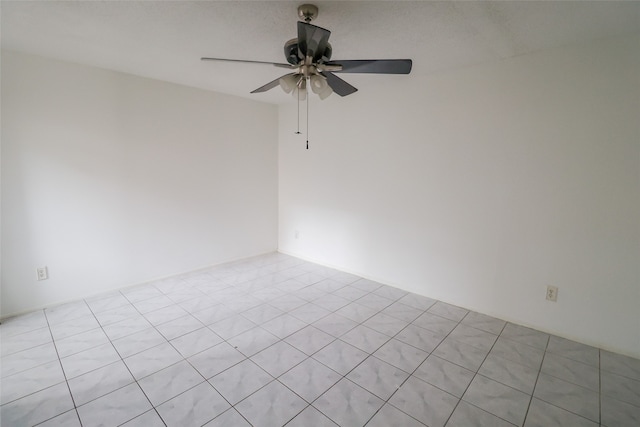 empty room featuring light tile patterned flooring and ceiling fan