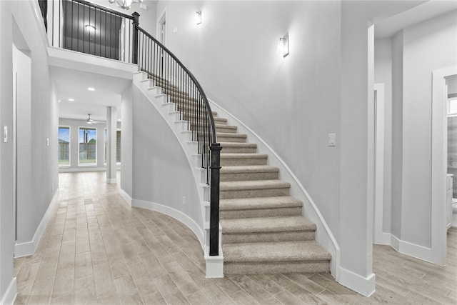 stairs featuring hardwood / wood-style floors and ceiling fan