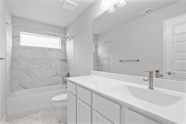 full bathroom with tiled shower / bath, vanity, and toilet