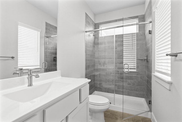 bathroom with vanity, walk in shower, tile patterned floors, and toilet