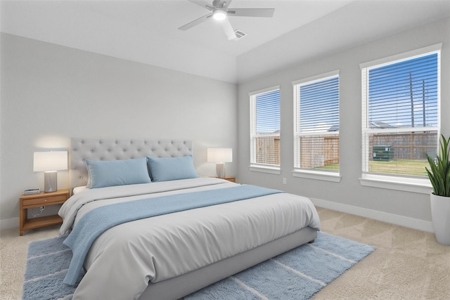 carpeted bedroom with multiple windows, vaulted ceiling, and ceiling fan