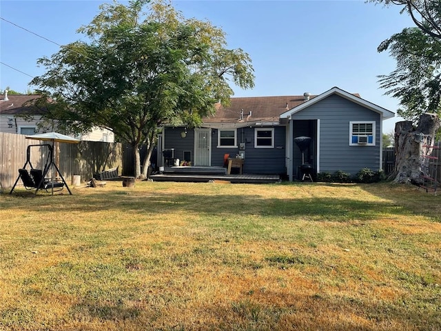 rear view of house with a deck and a lawn