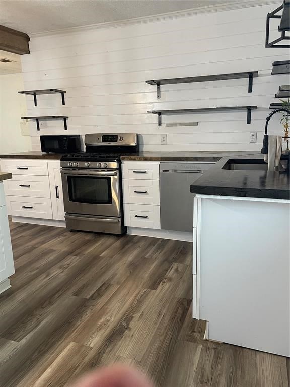 kitchen featuring sink, appliances with stainless steel finishes, white cabinetry, and dark hardwood / wood-style floors