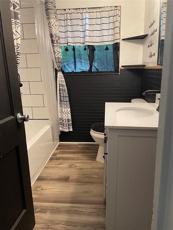 full bathroom featuring toilet, shower / bath combo, hardwood / wood-style floors, and vanity