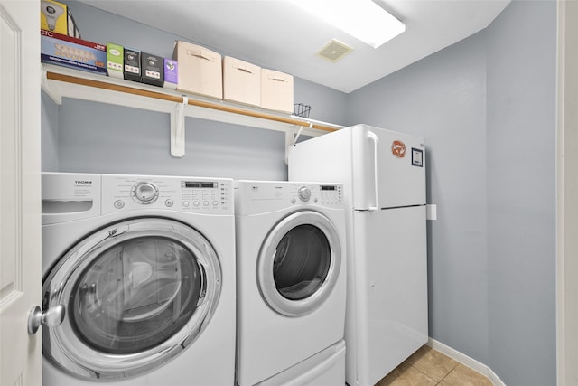 laundry area featuring light tile patterned floors and independent washer and dryer