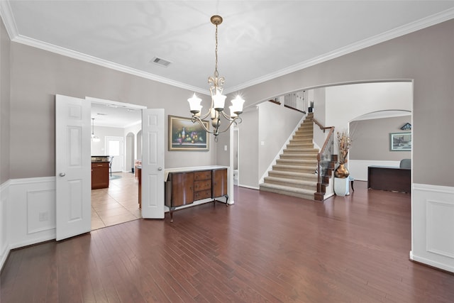 interior space featuring hardwood / wood-style flooring, a notable chandelier, and crown molding