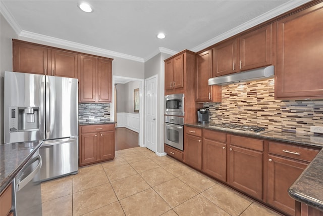 kitchen with dark stone counters, stainless steel appliances, light tile patterned floors, decorative backsplash, and ornamental molding