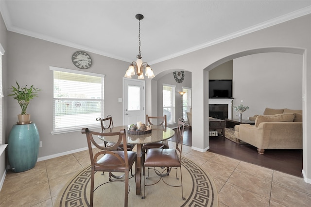 dining area with an inviting chandelier, crown molding, and light wood-type flooring