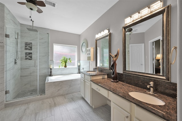 bathroom with plus walk in shower, ceiling fan, dual bowl vanity, and tile patterned flooring