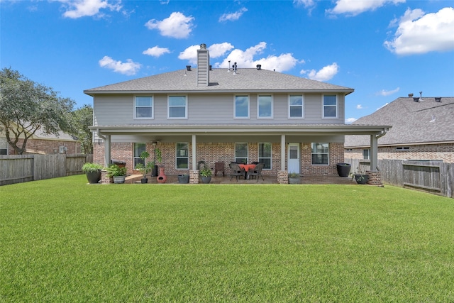 rear view of property featuring a patio and a lawn