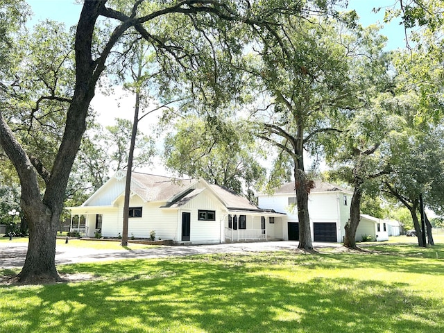 view of front facade featuring a garage, a front lawn, and covered porch