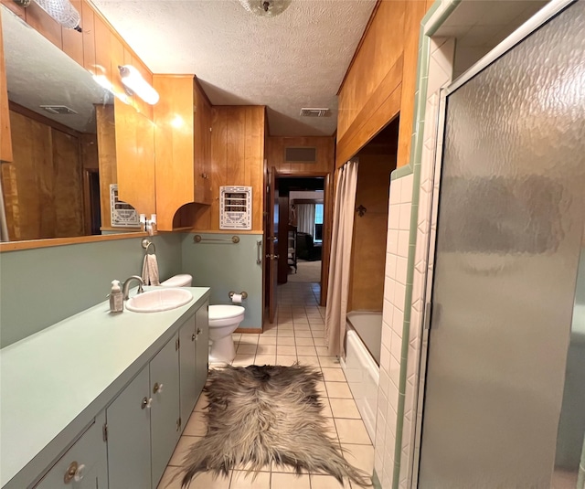 full bathroom featuring a textured ceiling, combined bath / shower with glass door, tile patterned floors, vanity, and toilet