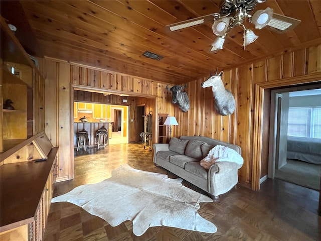 living room with wood ceiling, wooden walls, ceiling fan, and dark parquet flooring