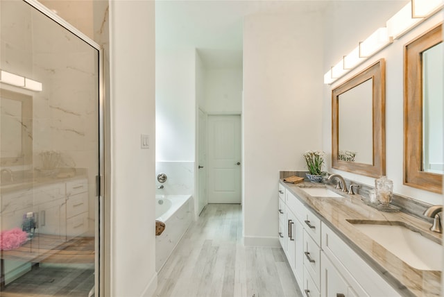 bathroom with hardwood / wood-style floors, separate shower and tub, and vanity