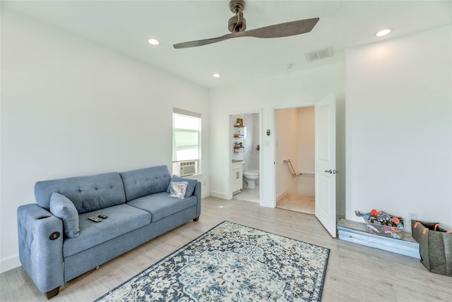 living room with ceiling fan, cooling unit, and light hardwood / wood-style flooring